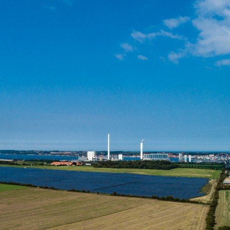 Solcelleparken på Asnæs med Asnæsværket i baggrunden.